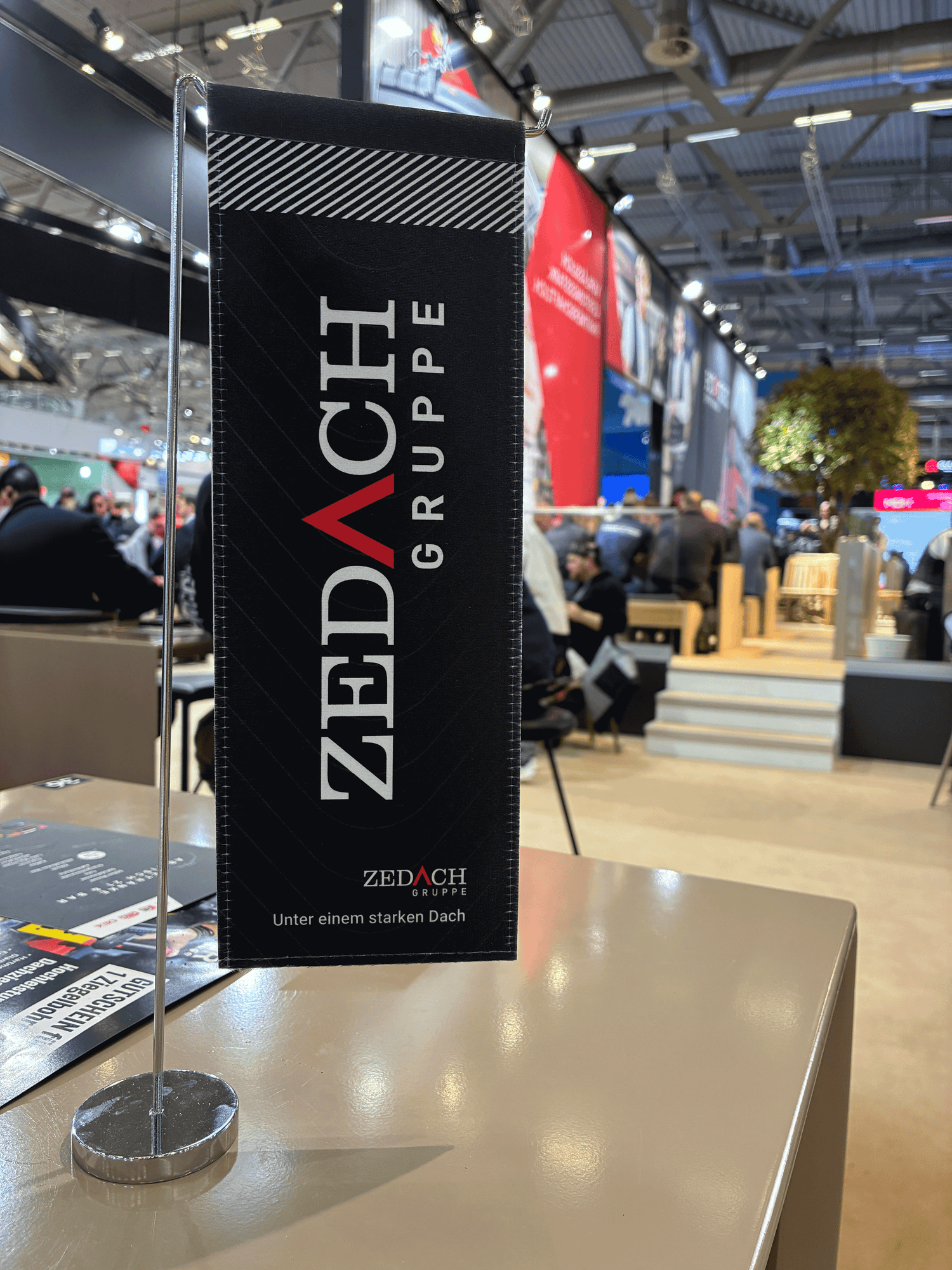 Tischaufsteller der Zedach Gruppe am Zedach Messestand der Dach+Holz 2026